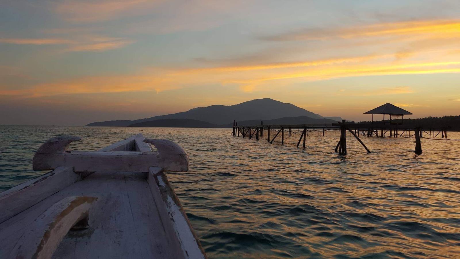 Zonsondergang boven zee, gezien vanaf een houten boot